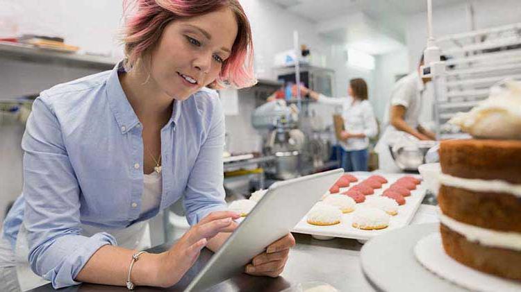 Bakery owner checking out small business retirement plans on an iPad.